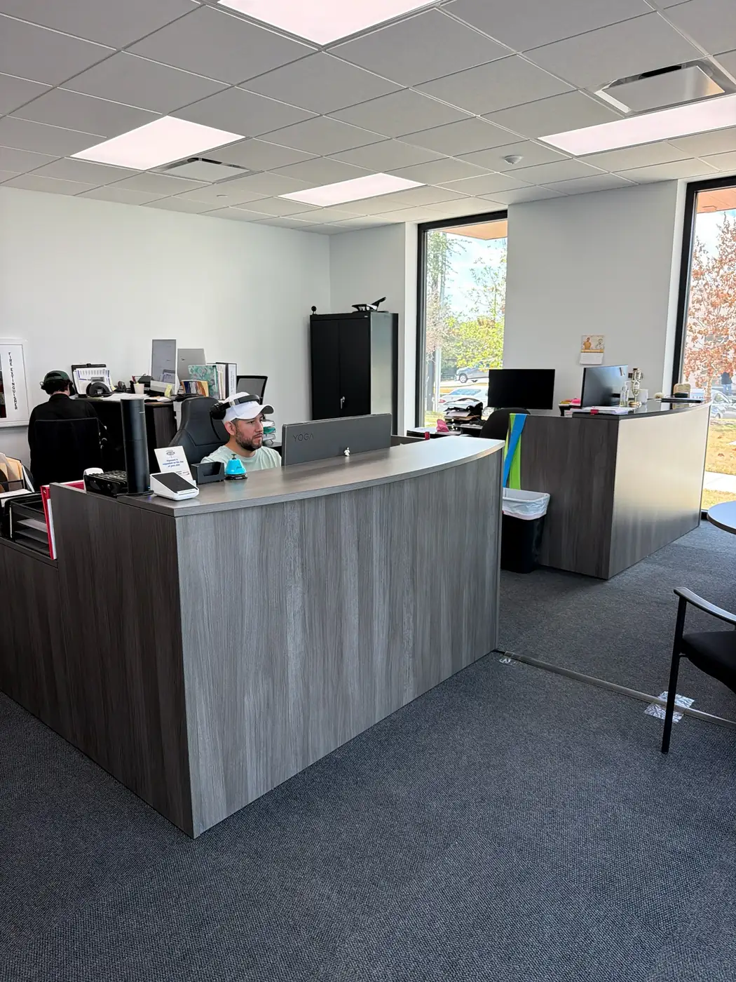 Two staff working at the reception desk inside the Master Glass Solutions office